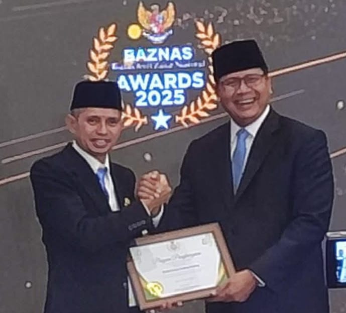 Ketua BAZNAS kota Padang Panjang, Syamsuarni, saat menerima piagam penghargaan.